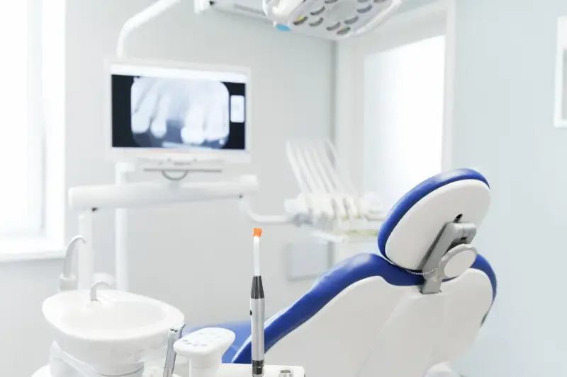 Gabinet dentystyczny z fotelem i aparaturą. Nawet gdy masz przeziębienie, dentysta czeka, by zadbać o Twój uśmiech.