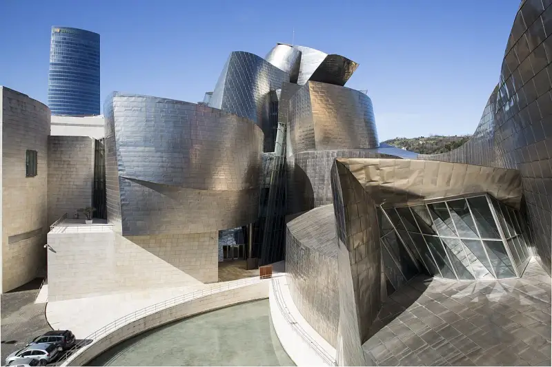 Spektakularny efekt Bilbao: falujące, metaliczne formy Muzeum Guggenheima w Bilbao, odbijające niebo i otoczenie.
