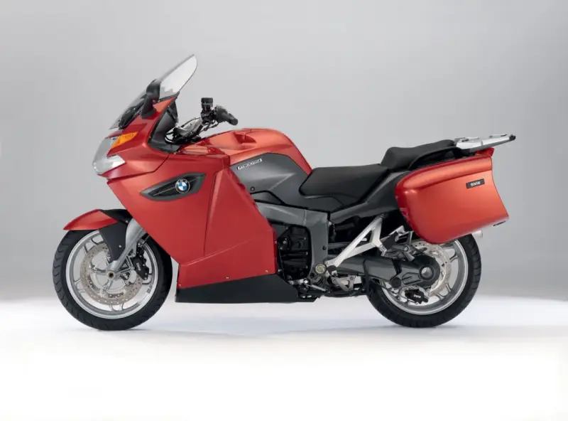 Czerwony motocykl turystyczny BMW K1300GT z kuframi, gotowy na długie podróże.