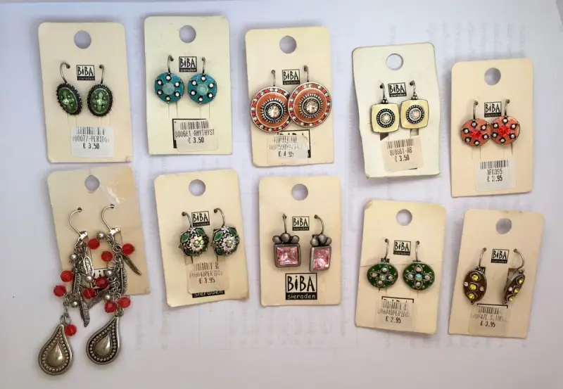 Kolczyki marki Biba Sieraden. Różnorodne wzory i kolory, od zielonych i niebieskich po pomarańczowe i różowe. Biba co to za marka? To marka biżuterii.
