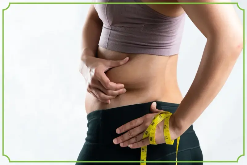 Osoba z obfitym brzuchem, mimo szczupłej sylwetki, mierzy talię. To przykład tzw. "skinny fat".