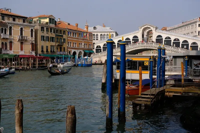 Venice canal with gondola, Rialto Bridge, and buildings.