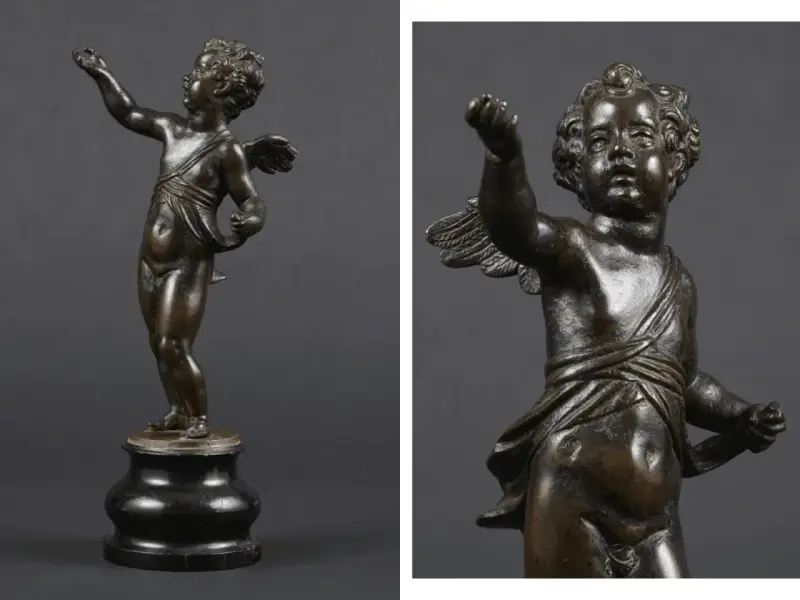 Brązowy putto z uskrzydlonymi plecami, w pozie gestykulacji, na ciemnym tle.