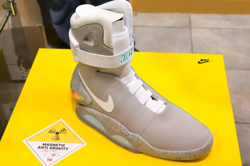 Nike Mag, najdroższe buty na świecie, z technologią "Magnetic Anti Gravity", prezentowane na żółtym tle.