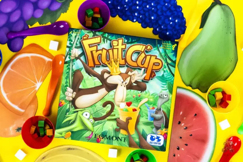 Gra Fruit Cup z owocami i kostkami. Małpa w koronie miesza owocowy deser.