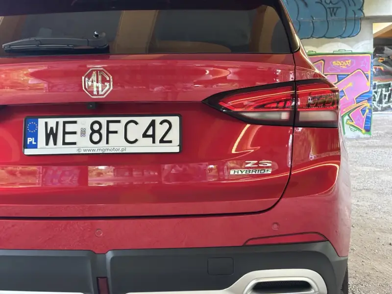 Czerwony tył samochodu MG ZS Hybrid z tablicą rejestracyjną WE 8FC42.