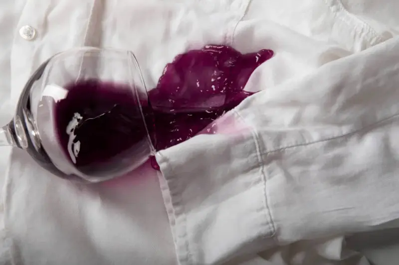 Un bicchiere rovesciato su una camicia bianca ha creato una macchia di vino rosso. Ecco come togliere macchie vino rosso secche.