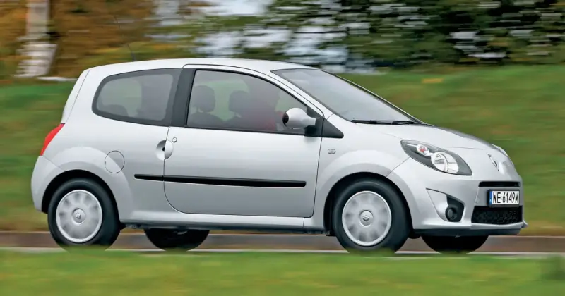 Srebrne Renault Twingo 2 w ruchu, z rozmytym tłem zieleni i drzew.