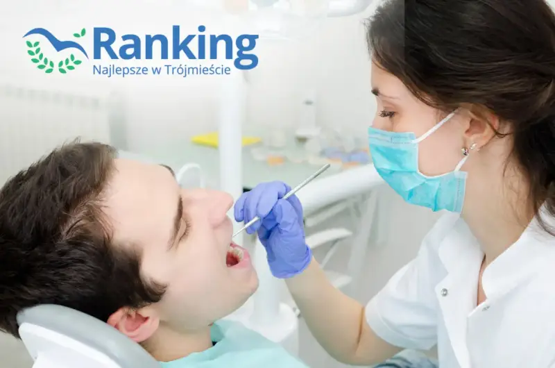 Dentystka w masce bada zęby pacjenta narzędziem stomatologicznym.