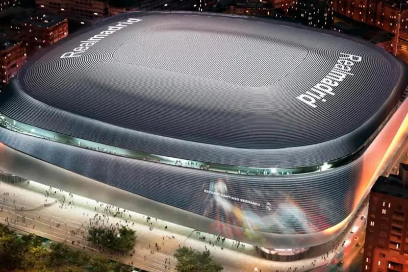 Nowoczesny stadion w Madrycie, Santiago Bernabéu, lśni w nocnym świetle.