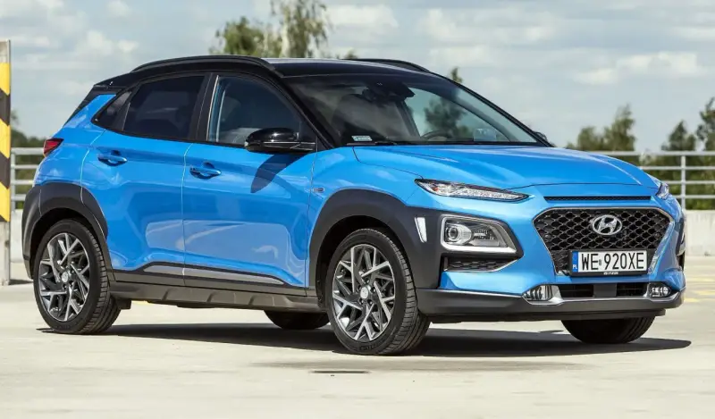 Niebieski Hyundai Kona 2025 z czarnym dachem, zaparkowany na zewnątrz.