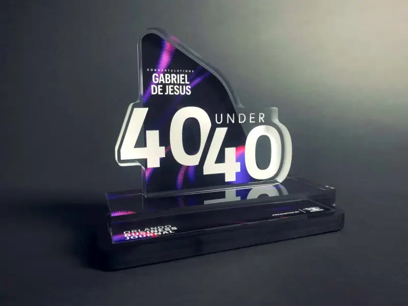 A "40 Under 40" award for Gabriel De Jesus, showcasing how strong is acrylic. The award features a sleek, modern design with vibrant purple and pink accents.