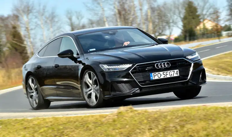 Czarny Audi A7 na drodze. Sprawdź aktualną audi a7 cena i możliwości tego sportowego sedana.