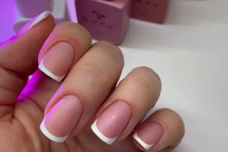 Dłonie z idealnym manicure, klasyczny french na paznokciach.