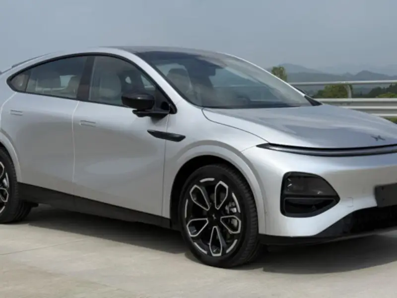 Srebrny SUV XPENG G6 z czarnymi felgami na tle krajobrazu.