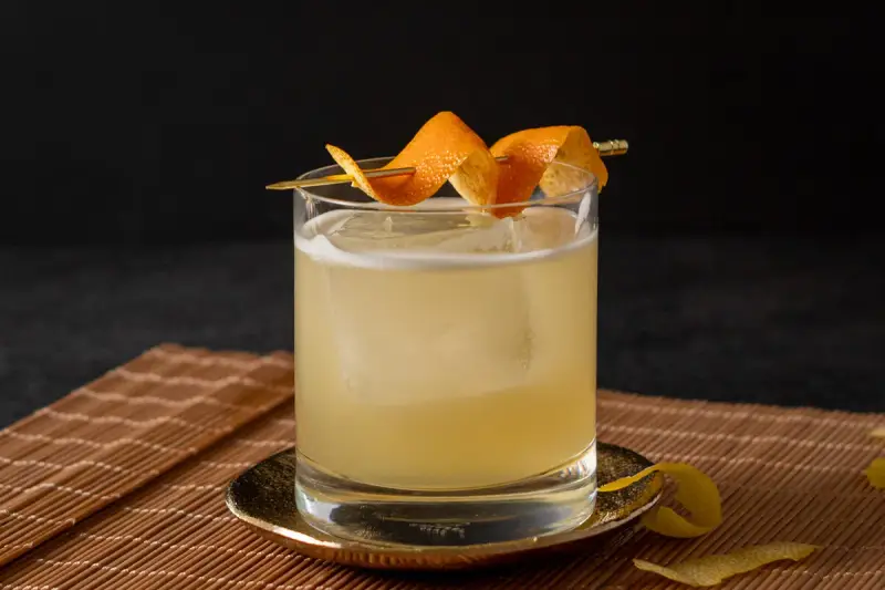 Ein erfrischender Cocktail mit Eis, garniert mit Orangenschale. Für die Süße wurde Zuckersirup verwendet, was ist Zuckersirup? Eine einfache Mischung aus Zucker und Wasser.