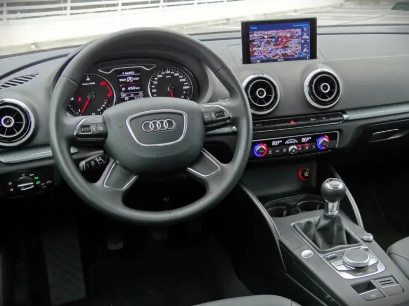 Wnętrze Audi A3 kombi: kierownica, nawigacja, panel klimatyzacji i skrzynia biegów.