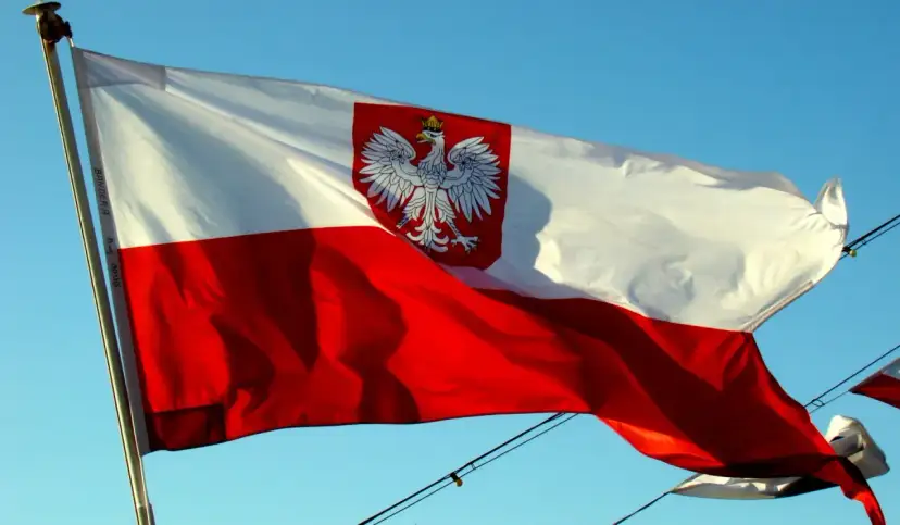 Polska bandera z orłem na tle błękitnego nieba. To symbol dumy narodowej, który powiewa na wietrze.