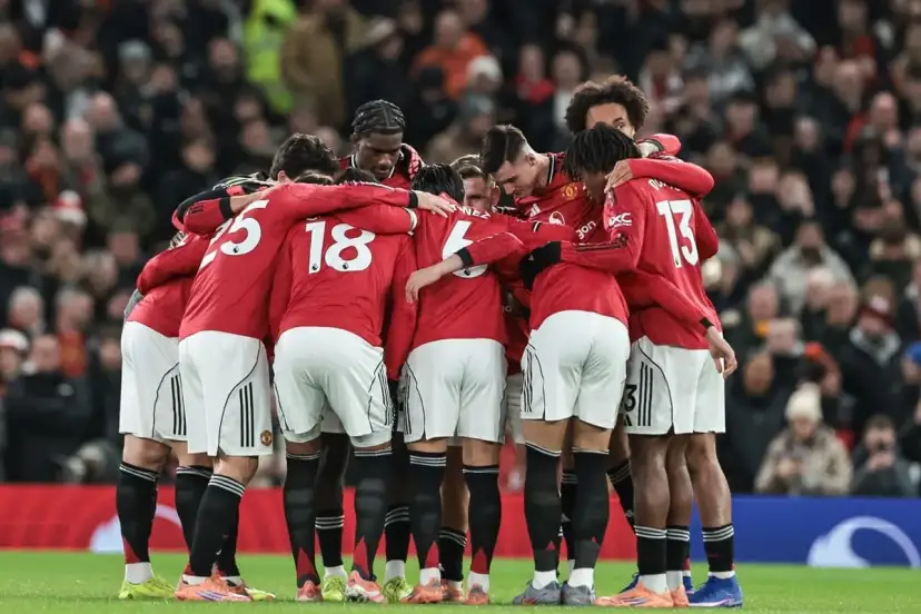 Piłkarze Manchesteru United w czerwonych strojach tworzą zwarty krąg, jednocząc się przed meczem. Ich wspólne united transfery budują ducha drużyny.