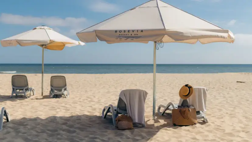 Leżaki i parasole na piaszczystej plaży nad morzem.