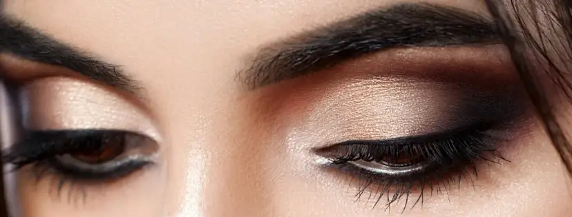 Nahaufnahme von Augen mit dezentem, strahlendem Make-up in Gold- und Brauntönen.