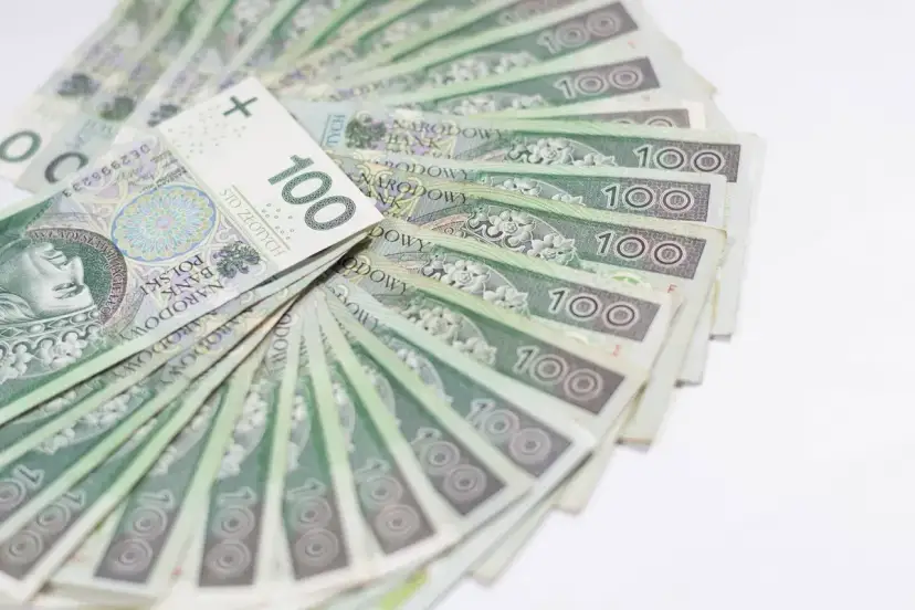 Stos stuzłotowych banknotów, ułożonych wachlarzowo. Idealne na świadczenie urlopowe, by odpocząć i cieszyć się wolnym czasem.
