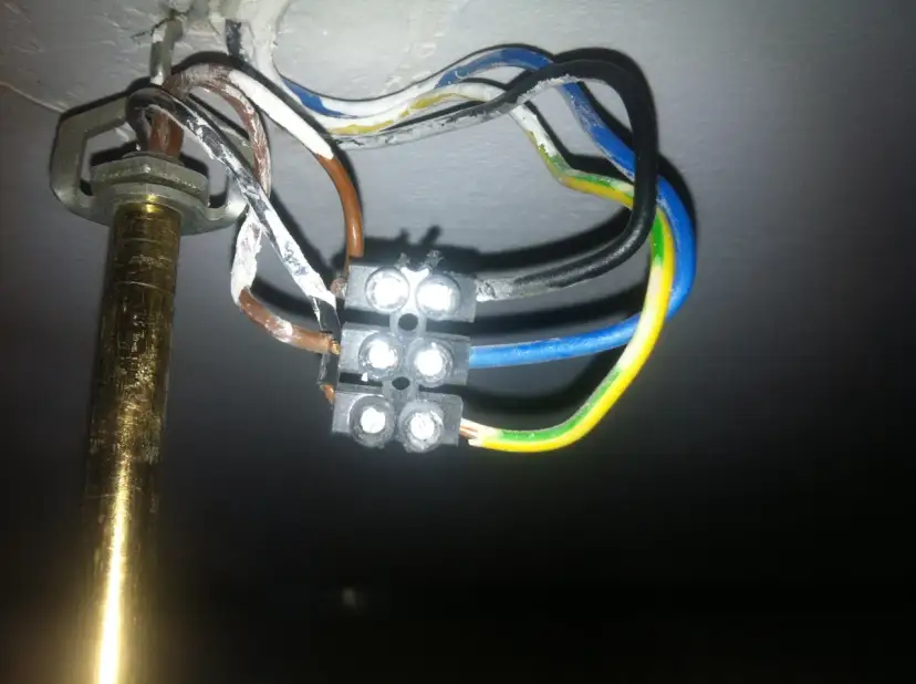 Widok z bliska na połączenie przewodów elektrycznych żyrandola z kostką.