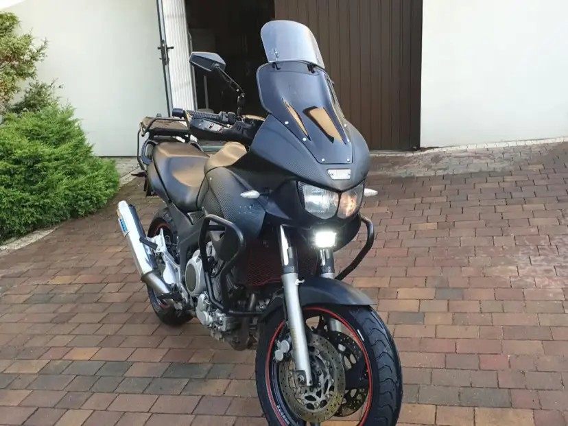 Czarny motocykl Yamaha TDM 850 z turystyczną owiewką i dodatkowymi światłami LED, gotowy na przygodę.