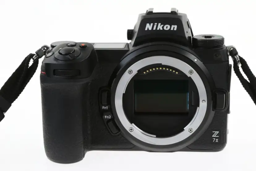 Czarny aparat Nikon Z7 III z obiektywem bez obiektywu, widoczny z przodu, z paskiem na nadgarstek.