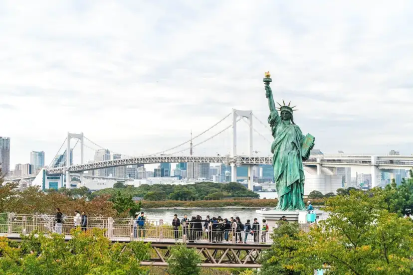 Replika Statuy Wolności w Tokio, gdzie jest statua wolności? W tle most Rainbow Bridge i panorama miasta.