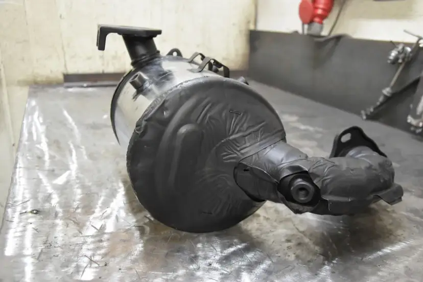 Część układu wydechowego, prawdopodobnie DPF, owinięta czarną taśmą. Czy dpf wypali się na postoju?