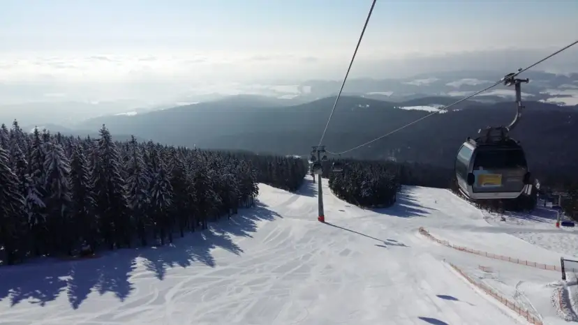 Widok z kolejki linowej na ośnieżony stok narciarski. Sprawdź jańskie łaźnie ski cennik i zaplanuj swój wyjazd!