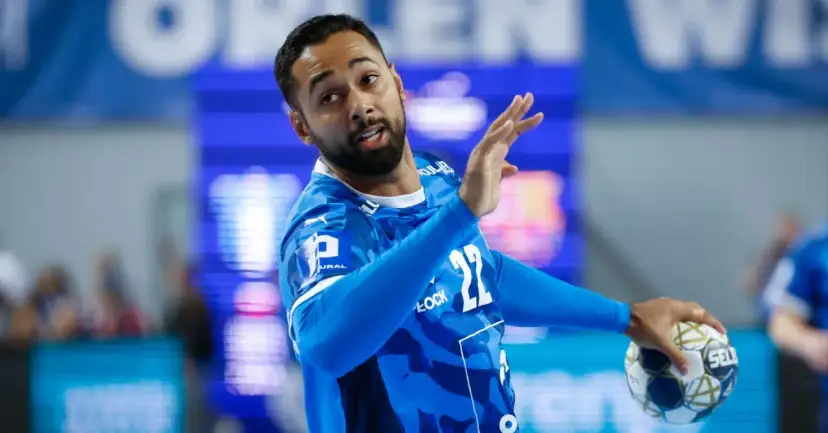Gracz gog handball w niebieskiej koszulce z numerem 22, gotowy do rzutu.