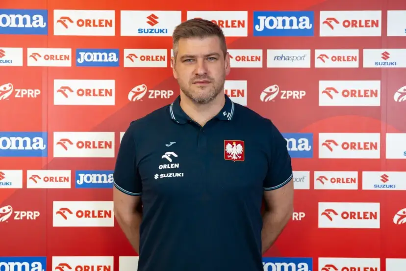 Mężczyzna w koszulce z orłem, podobny do Julena Aginagalde, stoi na tle ścianki z logotypami sponsorów, m.in. ORLEN.