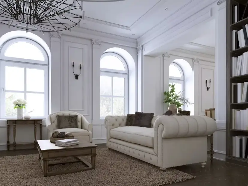 Elegancki salon z sofą, fotelem i książkami na półce.