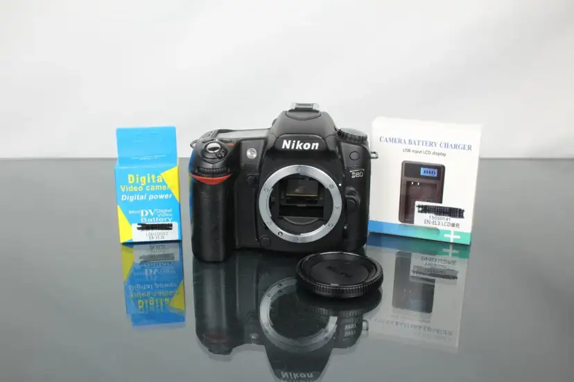 Nikon D80 z akcesoriami: ładowarka i bateria do aparatu cyfrowego.