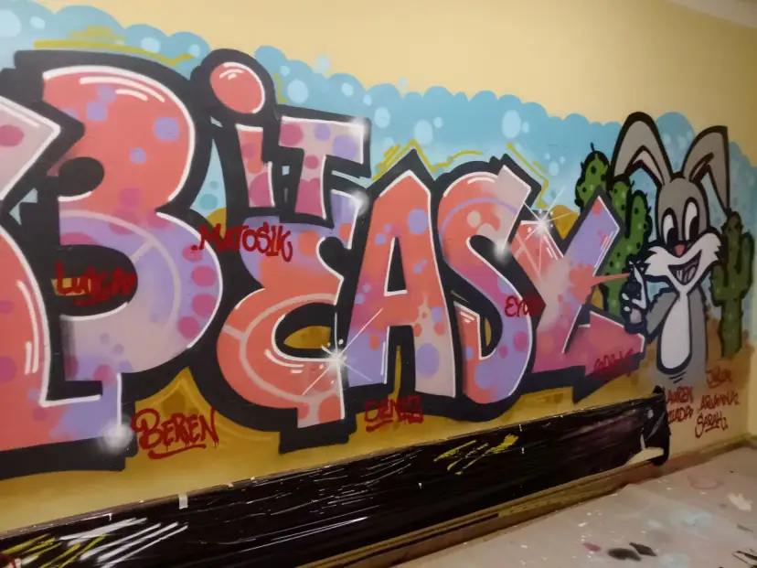 Buntes Graffiti mit Schriftzug "BIT EASY" und einem Hasen vor Kakteen.