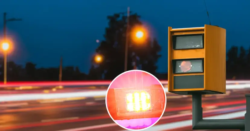 Pomarańczowa skrzynka fotoradaru na tle nocnej drogi z rozmazanymi światłami. Czy zawsze przychodzi mandat z kamery?
