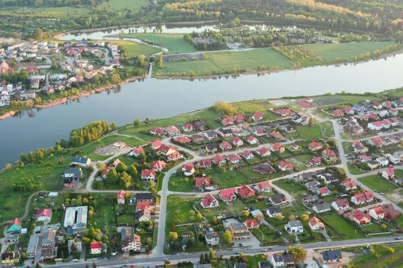 Widok z lotu ptaka na malownicze jezioro Pniewy otoczone zielenią i zabudowaniami.