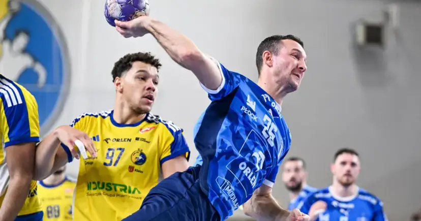 Gracz w niebieskiej koszulce rzuca piłkę, podczas gdy przeciwnik w żółtej koszulce z numerem 97 próbuje go zablokować. Emocjonujący mecz piłka ręczna liga mistrzów.