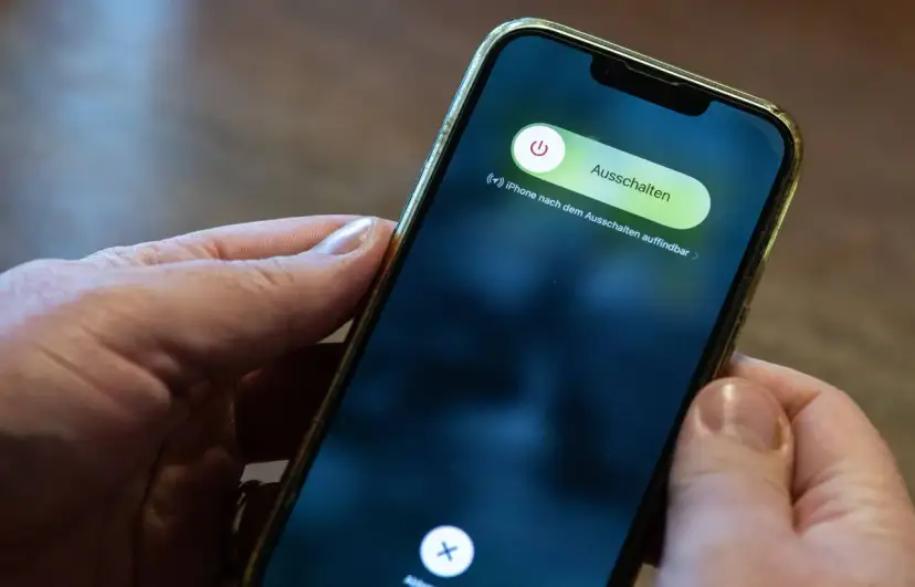 Hände halten ein iPhone mit dem Ausschaltmenü.