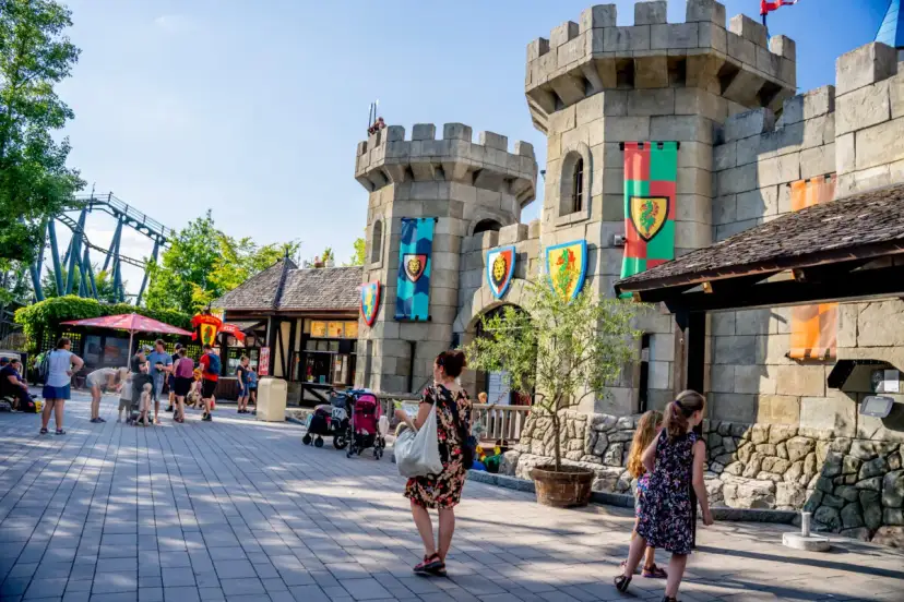 Rodzina zwiedza zamek w Legolandzie, zastanawiając się, czy to Legoland Niemcy czy Dania. W tle widać kolejkę górską.