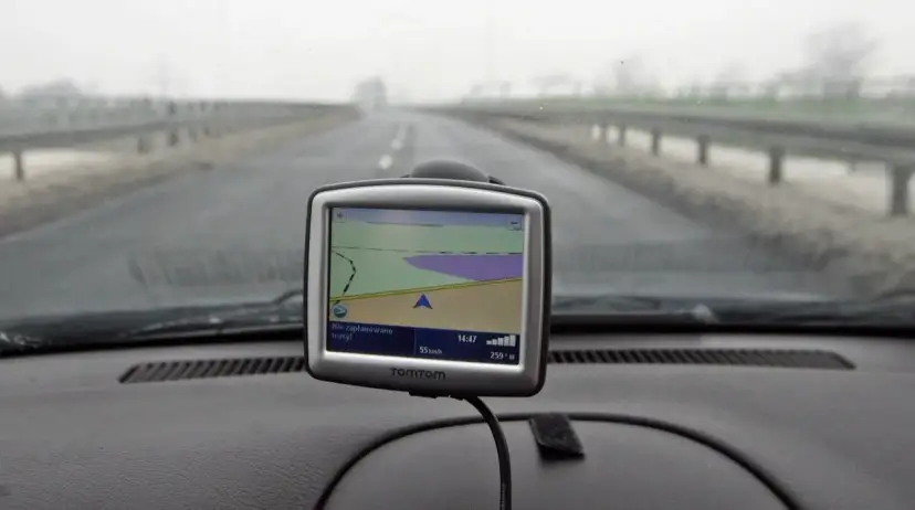 Nawigacja TomTom na desce rozdzielczej samochodu podczas jazdy w mglisty dzień.