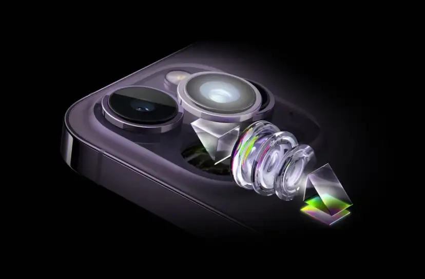 Rozłożony aparat iPhone 15 z soczewkami i pryzmatami, ukazujący zaawansowaną technologię optyczną.