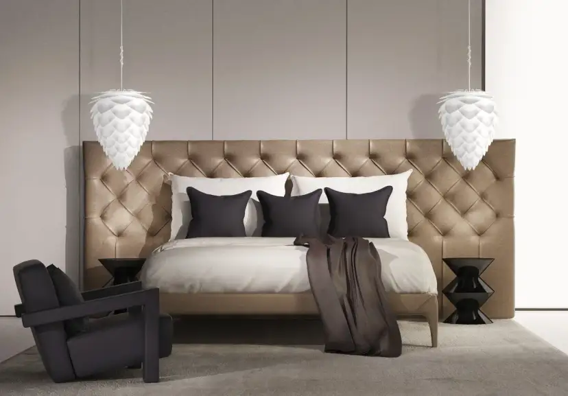 Elegancka lampa sufitowa do sypialni w kształcie szyszki, wisząca nad luksusowym łóżkiem z pikowanym zagłówkiem.