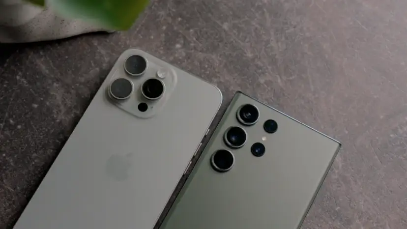 Dwa najnowsze fotosmartfony, iPhone i Samsung, leżą obok siebie na ciemnym tle.