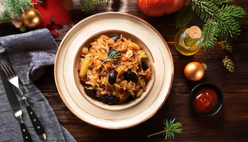 Pyszny bigos z kiszonej kapusty, podany na talerzu, z dodatkami i świątecznymi ozdobami.