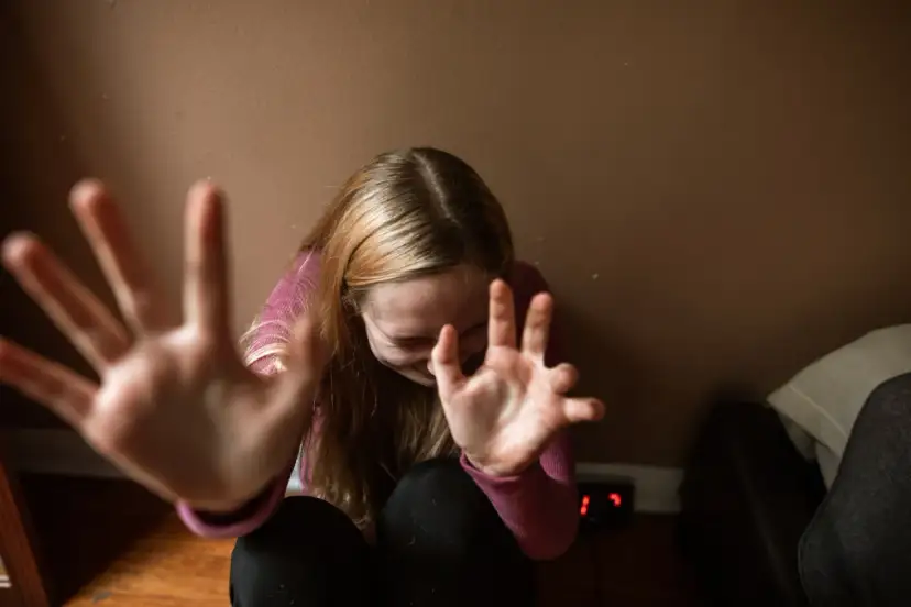 Dziewczyna z rękami przed twarzą, wyrażająca niepokój.