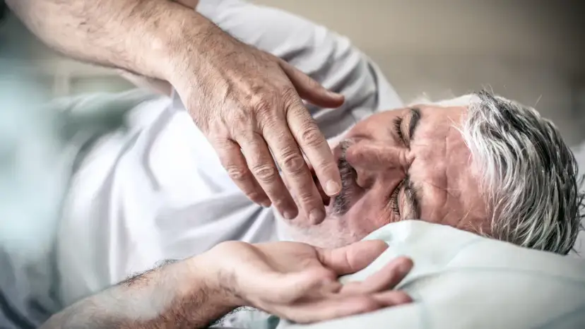 Starszy mężczyzna śpi, jego dłoń delikatnie dotyka twarzy. Może to być odpowiedź na pytanie, dlaczego starsi ludzie dużo śpią – potrzebują regeneracji.