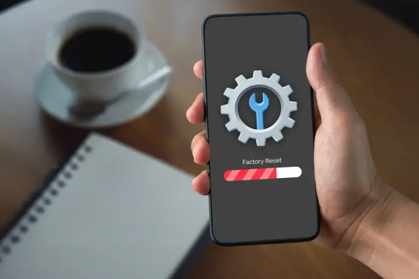 Telefon z ikoną narzędzi i paskiem postępu "Factory Reset". To może pomóc, gdy chcesz naprawić dotyk w telefonie.